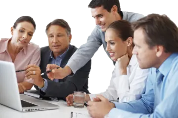 a group of people sitting around a laptop