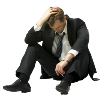 a man in a suit and tie sitting on the ground