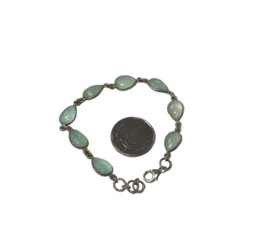 a silver bracelet with green glass beads