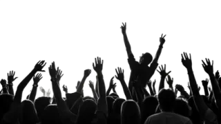 a crowd of people raising their hands in the air