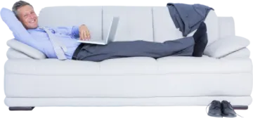 a man laying on a couch with his laptop