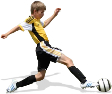 a young boy kicking a soccer ball
