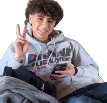 a boy sitting on top of a couch holding a cell phone