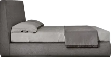 a gray bed with pillows on top of it