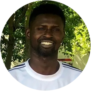 a man in a white shirt smiles at the camera