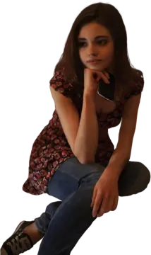 a woman sitting on the ground with her hand on her chin