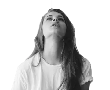 a woman with long hair and white shirt looking up at the sky