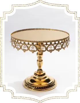 a gold - plated cake stand on a white background
