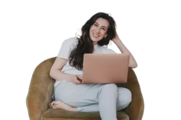 a woman sitting in a chair with her laptop