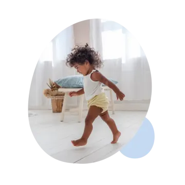 a baby running on the floor in a white room