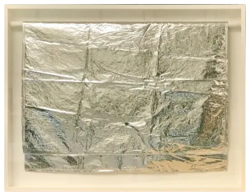 a piece of aluminum foil in a white frame