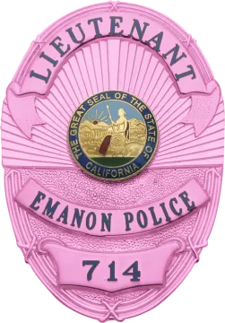 a pink police badge with the name of an officer