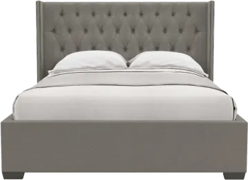 a bed with a grey headboard and white pillows