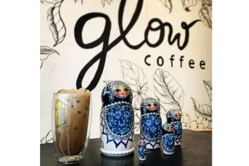 two cups of coffee and a glass with a drink in it