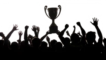 a crowd of people raising their hands in front of a trophy