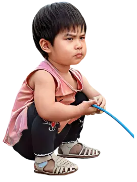 a small child sitting on the ground with a toothbrush