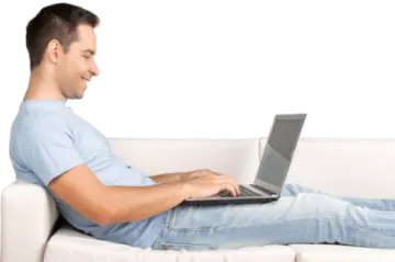 a man sitting on a couch using a laptop