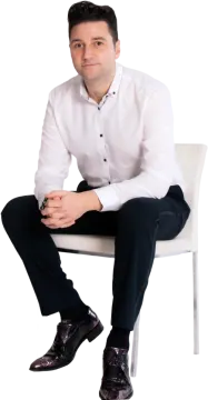 a man in a white shirt sitting on a chair
