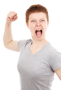 a woman in a gray shirt holding up her fist