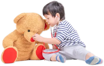 a little boy playing with a teddy bear