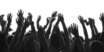a crowd of people raising their hands in the air
