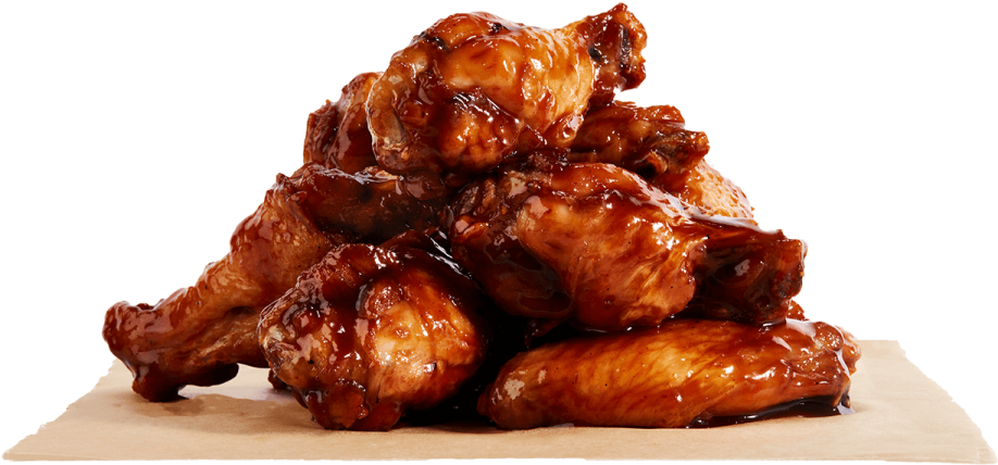 a pile of chicken wings with sauce on top