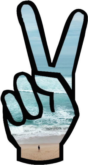 a peace sign on a beach with the ocean in the background