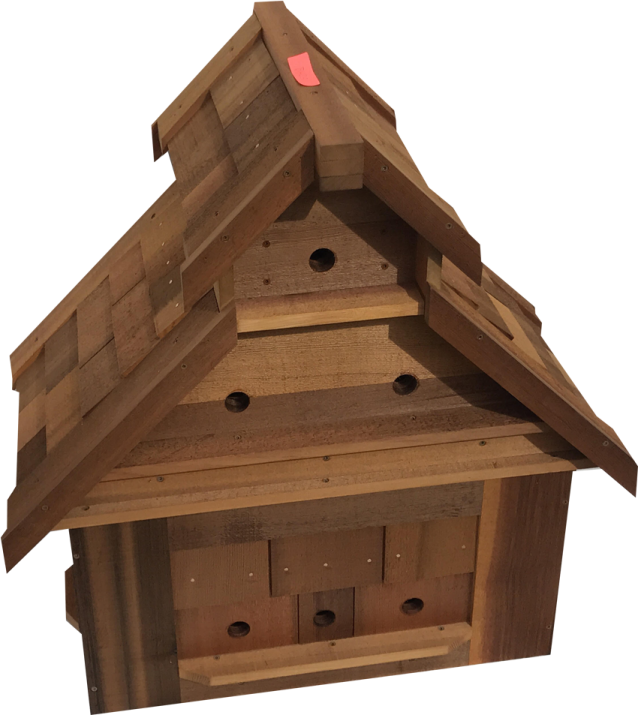 a wooden bird house with a red heart on the roof