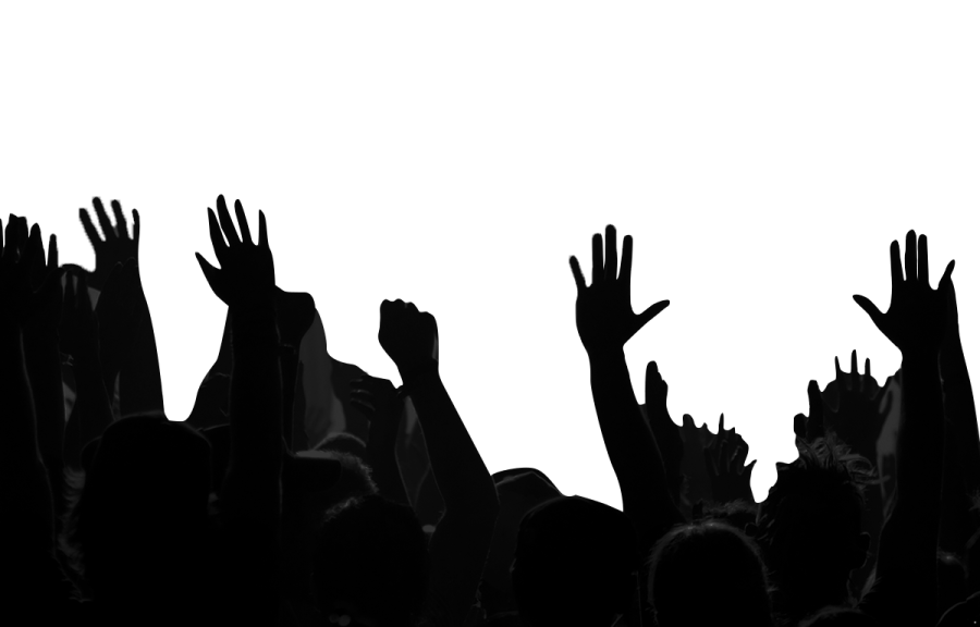 a crowd of people raising their hands in the air