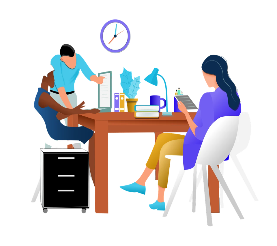 two people sitting at a table working on laptops