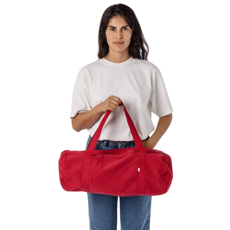 a woman holding a red duff bag