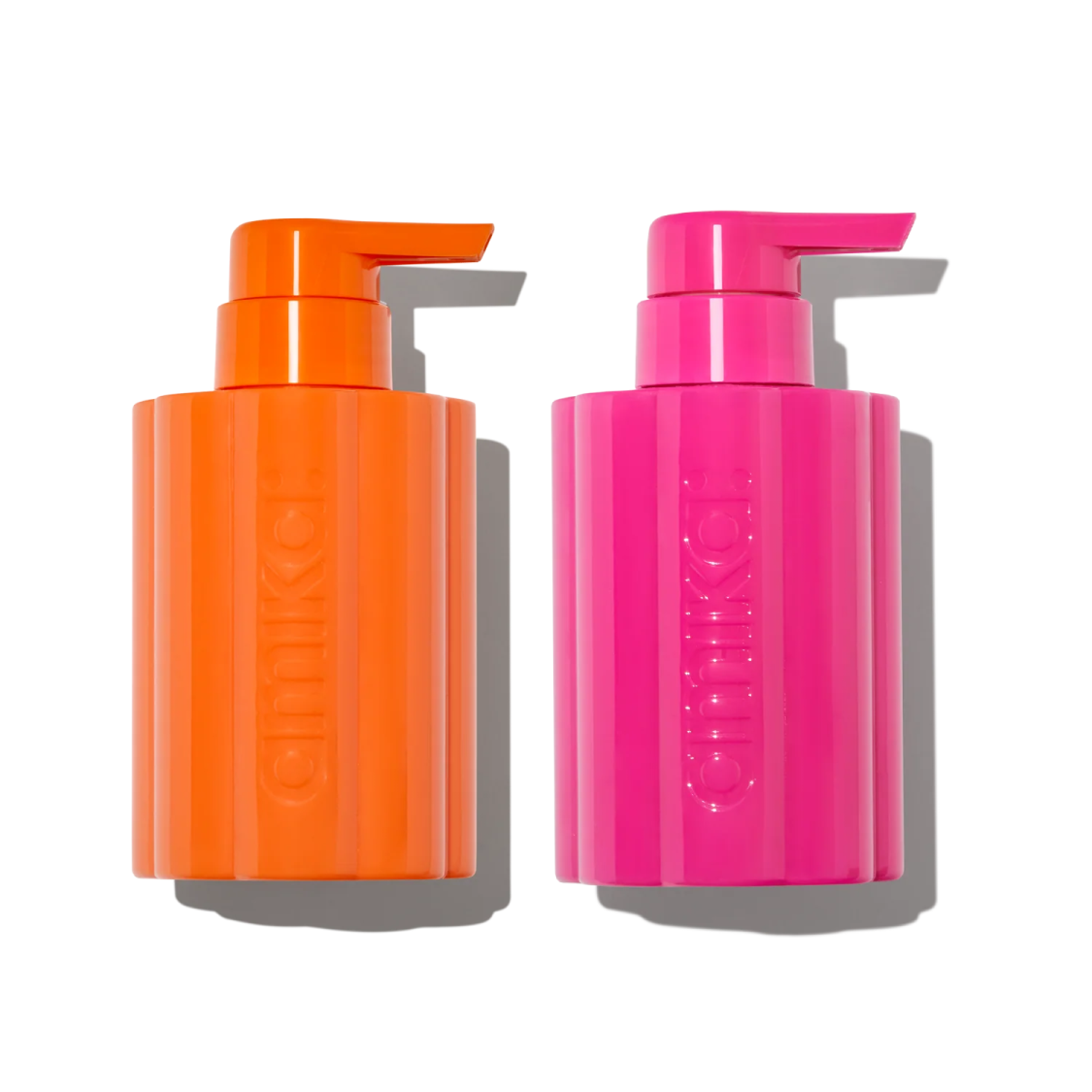 a bottle of orange and pink liquid next to each other bottles