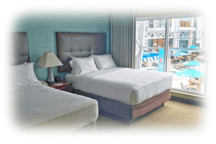 two beds in a hotel room with large windows