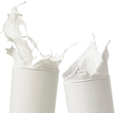 two cups with milk splashing out of them