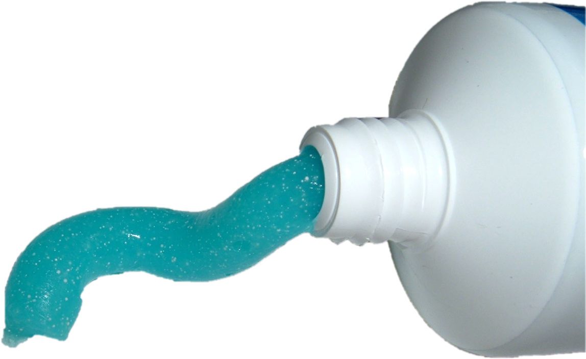 a bottle filled with blue liquid next to a white wall