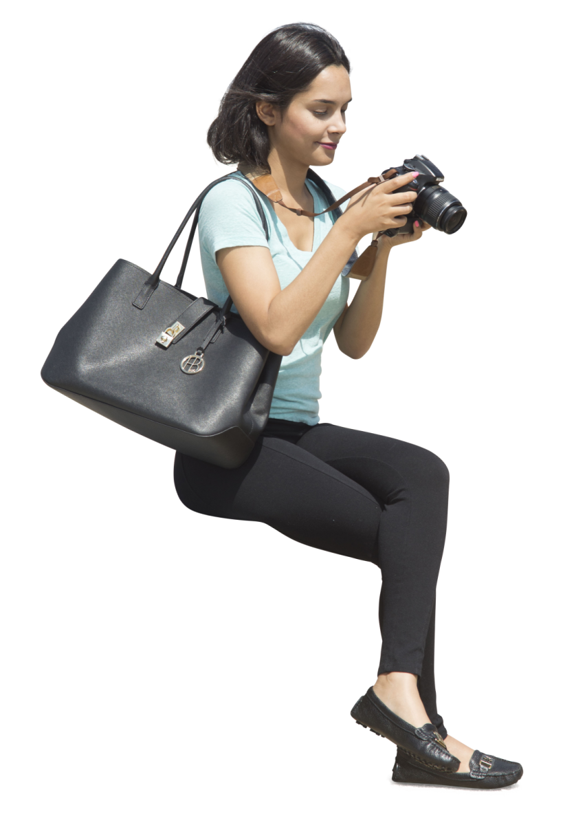 a woman sitting on the ground holding a camera