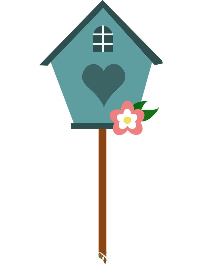 a bird house with a flower in the grass