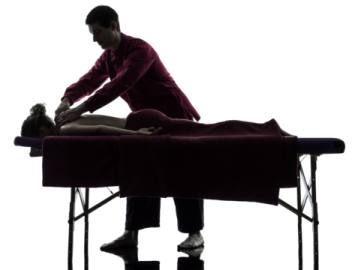 a man is sitting on a massage table
