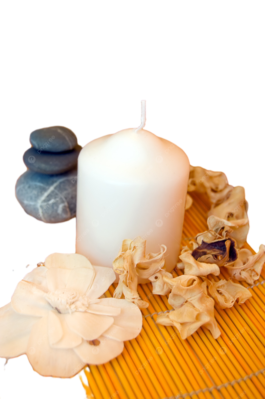 a candle and some flowers on a bamboo mat