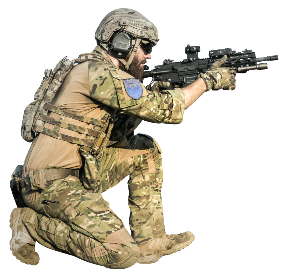 a man in camouflage gear crouching down with a rifle