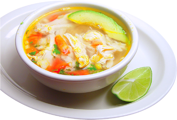 a bowl of chicken soup on a white plate