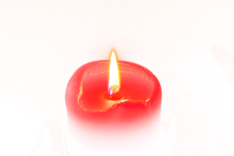 a red candle sitting on top of a table