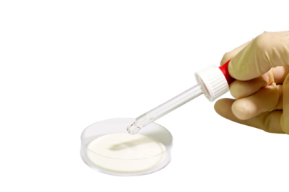 a hand holding a vial filled with white liquid