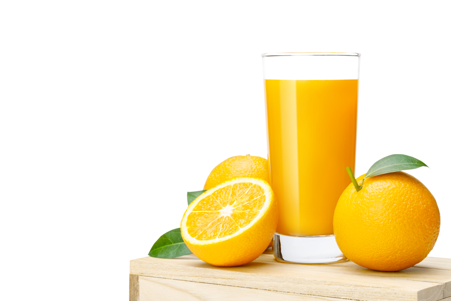 a glass of orange juice next to two oranges