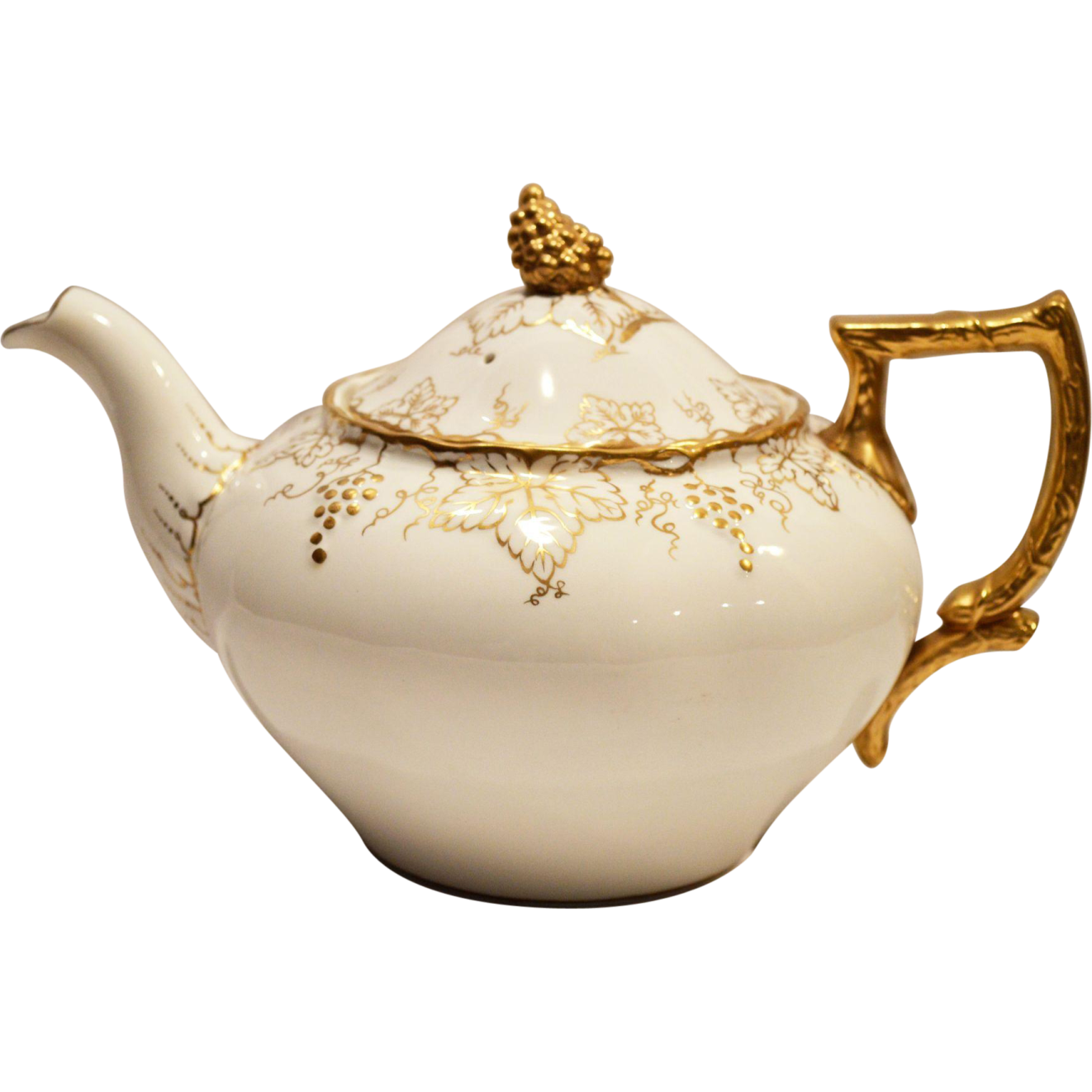 a white tea pot with gold trimming