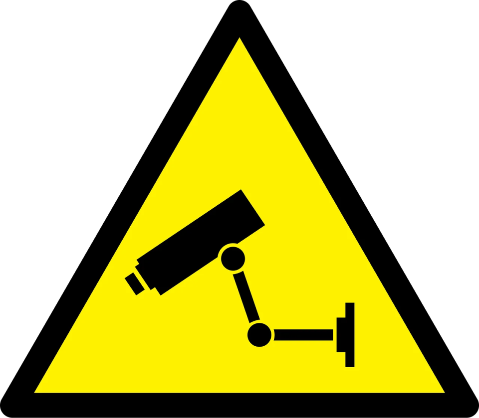 a yellow and black sign with a camera