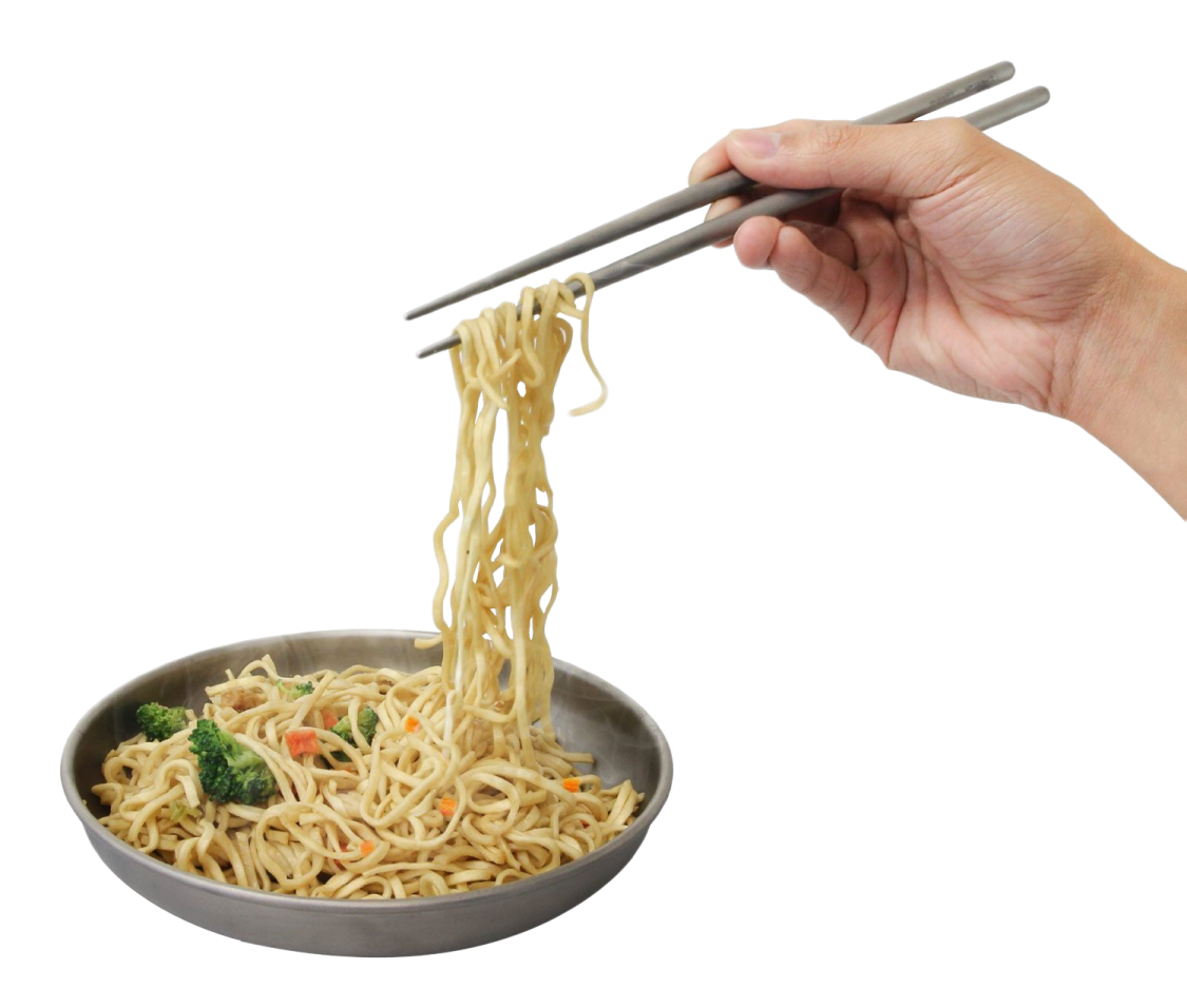 a person holding chops over a bowl of noodles