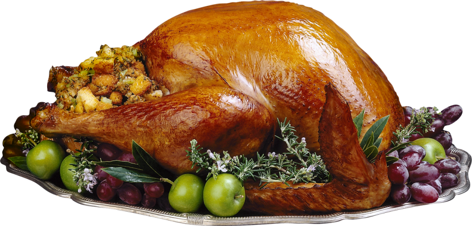 a turkey sitting on top of a platt of fruit and vegetables