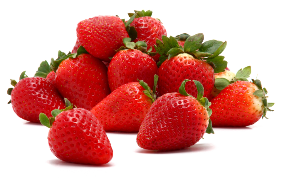 a pile of strawberries with green leaves