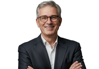 a man in a suit and glasses with his arms crossed